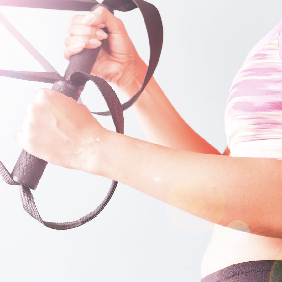 fitness-female-pink-sport-bra-holding-hands-with-trx-copy-space (1)